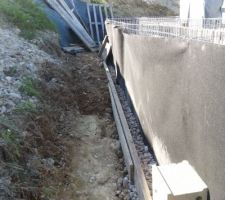 A l'arrière, on remblaie avec des cailloux à côté des gabions et de la terre.