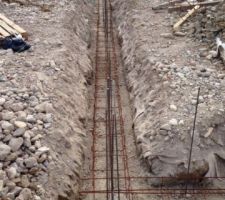 On a coulé 70cm de beton de proporeté et planté nos attentes verticales dans le béton quelques minutes après la coulée tous les 50 cm 10 mm et 8 mm alternativement. Trois fers 10mm dans les angles et aux endroits des futures poutres. un beau boulot très content du resultat. on a posé nios longrines sur ce beton ligaturés dans les angles et sureleves de 2-3cm pour assurer un bon enrobage au moment de couler le beton de fondation.
