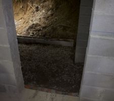 Nous avons utilis&eacute; le sable et les cailloux laiss&eacute;s par le ma&ccedil;on pour tapisser le sol de la future cave.