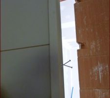 On a fixé des grosses visses en biais dans le cadre de la porte qui viennent ensuite s'encastrer dans le mur. Après, on a tout plâtré - et ça tient!