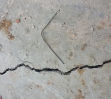Fissures de retrait sur la dalle du RDC, test de profondeur avec un trombone sur la plus grosse : il s'enfonce qd même de 3cm environ !!