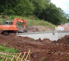 Terrassement et remblaiement des extérieurs avant l'élévation des murs.