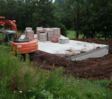 Terrassement et remblaiement des extérieurs avant l'élévation des murs.