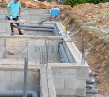 En train de faire la plomberie du vide sanitaire