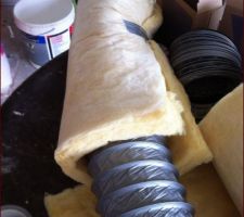 Mise en place de l'isolant autour de la gaine fix&eacute; au scotch toile.