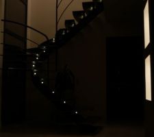 Escalier et niches éclairées dans la nuit.