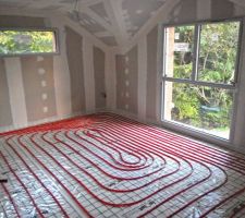 Vue du réseau de canalisation du plancher chauffant dans la chambre parentale