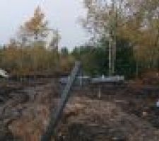 Vue panoramique de la route d'entr&eacute;e dans le lotissement et de notre futur terrain (&agrave; droite, avec le bois et les engins)