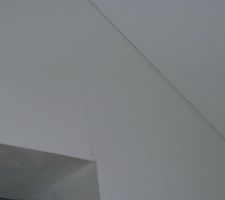 Fissures des angles rentrants du plafond et sur le mur.
