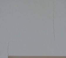 Fissures au dessus de la porte du cellier dans le couloir et dans l'encadrement de porte .