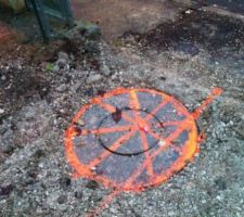 Pose de la couverture de l'ancien regard de l'évacuation des eaux usées de la maison voisine qui passe sous l'accès à notre terrain