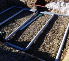 Par dessus les gravillons, installation des tuyaux de drainages