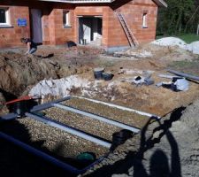 Par dessus les gravillons, installation des tuyaux de drainages