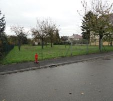 Terrain vu de la rue, le Nord se situe donc &agrave; gauche. Le terrain est en pente descendante c&ocirc;t&eacute; Est.