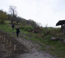 Voici la partie OUEST de la maison. Les petits plots sont la délimitation de notre terrain. Ma copine, de dos, passe sur un chemin agricole (servitude de passage)