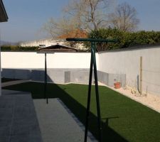 Gazon synth&eacute;tique derri&egrave;re la maison avec jardin potager en pr&eacute;paration