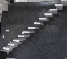Escalier suspendu avec marches blanches et mur gris