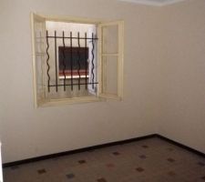 Chambre qui va devenir le salon avec un escalier allant au garage