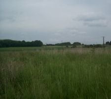 Vue prise du fond du terrain on apper&ccedil;oi la borne toute petite pres de la route