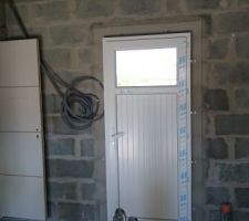 Porte du garage avec occulus et celle menant à la cuisine