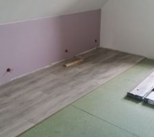 Pose flottante du parquet sur sous-couche dans la chambre parentale.