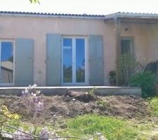 La chape de la terrasse terminée devant avec la terre de jardin pour faire une plate-bande de fleurs.