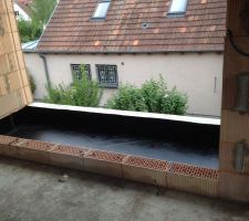 Pose de la couche d'étanchéité au sol du balcon couvert.