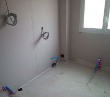 La salle de bain du bas. En bas de la fenêtre on voit l'emplacement pour le chauffage, à gauche les wc suspendus, au milieu pour le lavabo. Sur le mur, une prise et un applique
