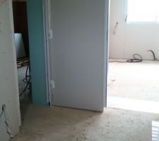 Le cellier avec à gauche la porte qui mène au garage et devant la porte vers la cuisine.
