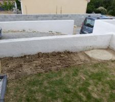 Bac qui attend son g&eacute;otextile, ses bordures grises anthracites et des graviers blancs.