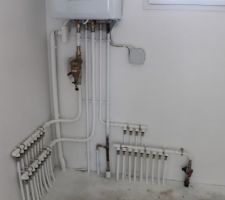 Tuyauterie sous la chaudière: tuyaux radiateurs à gauche, tuyaux robinets eau chaude et eau froide à droite.