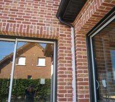 Une descente de gouttière entre baie cuisine et baie d'angle