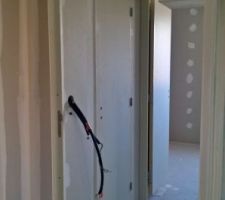 Entrée avec vue sur la chambre 1, le placard, les sanitaires et le cellier.