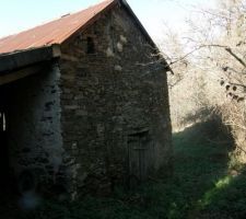 En haut du terrain la porte en bois donne sur le foudre