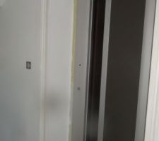 Finitions de l'entourage de l'ascenseur en posant des chambranles assorties aux autres portes