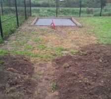 Préparation de la dalle sur laquelle reposera l'abri de jardin en bois.