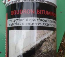 Goudron de protection passé au bas du mur