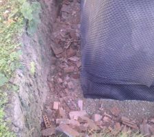 Enfouissement déchet construction, au passage déchirure de l?étanchéité par projection des débris de briques.