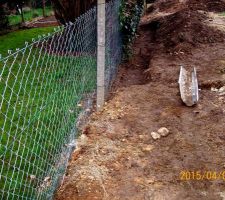 Retrait du remblai pour remise à niveau du terrain naturel en limite de propriété voisine. Clôture grillagée endommagée par les poussées de terres.