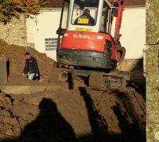 Mini pelleteuse juchée sur le mur de rampe de sous-sol