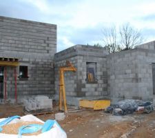 Vue de la maison côté entrée, avec porte d'entrée à gauche et garage à droite, cellier au milieu