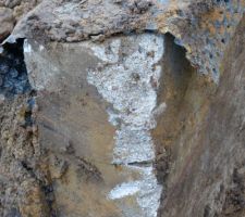 Bout du mur de rampe de sous-sol endommagé par la pelleteuse