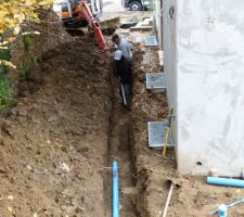 Passage de la gouttière entre la canalisation désaffectée et les murs de soutien le long de la maison