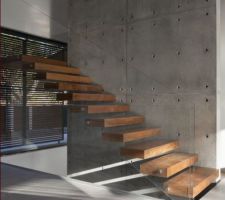 Escalier suspendu, marches bois, sur mur d'echiffre bardé de plaques béton supra-léger