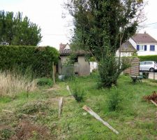 Partie arrière du terrain et garage. Clôture qui a commencé à être démontée.