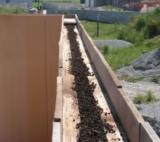 On démonte le haut du mur, qui tient grâce aux AGEPAN et aux poutres en I.
Ensuite, on déverse le liège dans les murs directement puis on compresse bien comme il faut avant de remettre la planche en haut du mur avant qu'il ne reprenne sa forme...
Et voilà comment on isole le mur par déversement, sans trou ^_^