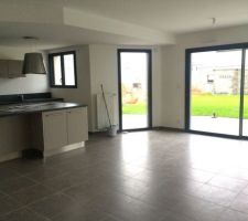 Le coin salon avec l'ilot de la cuisine à gauche