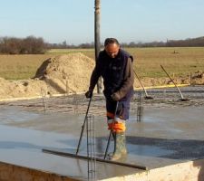 Béton Michel en train de sortir les bulles d'air du béton pour lisser la dalle