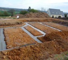 Photo prise de derrière la maison.
A gauche: le garage
Dans le pan coupé: porte d'entrée; placard, wc
Au milieu: cuisine devant dans l'avancée et derrière le bureau
A droite: séjour et salon