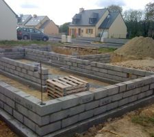 Après achevement des semelles en béton armé. Début des rangs de parpaings pour le vide sanitaire sous maison et garage.
